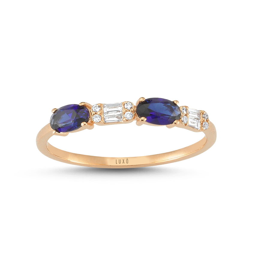 Rose gold ring with two sapphire gemstones that sit beside baguette and round-cut diamonds